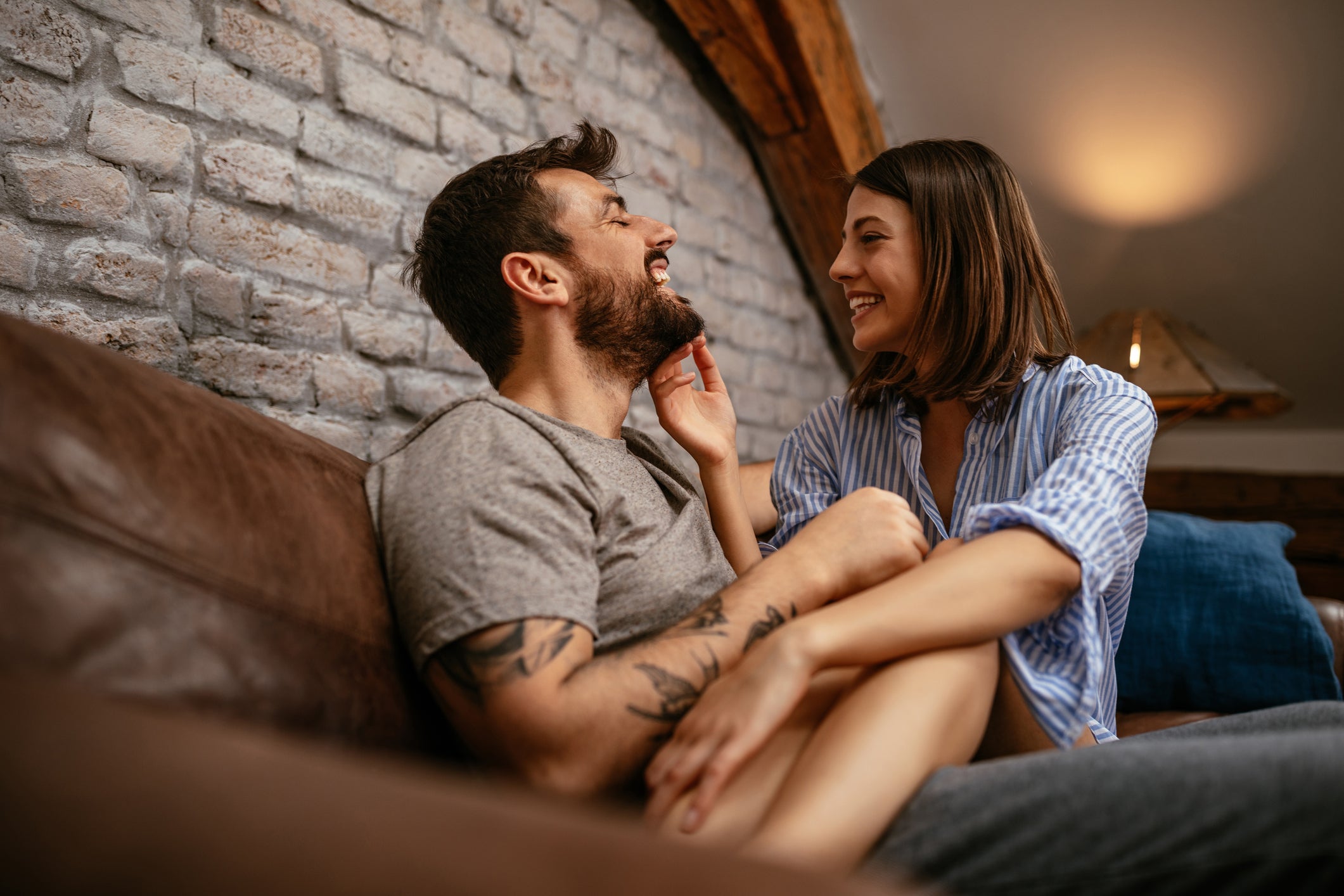 A man and woman on a couch laughing together