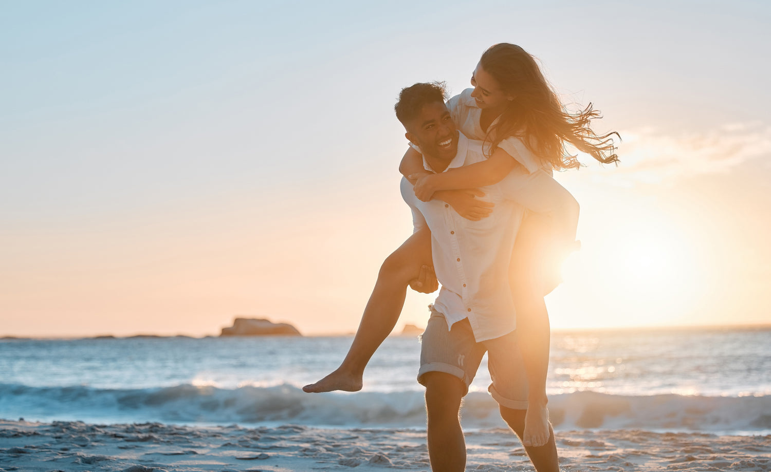 A man carrying a woman at the beach