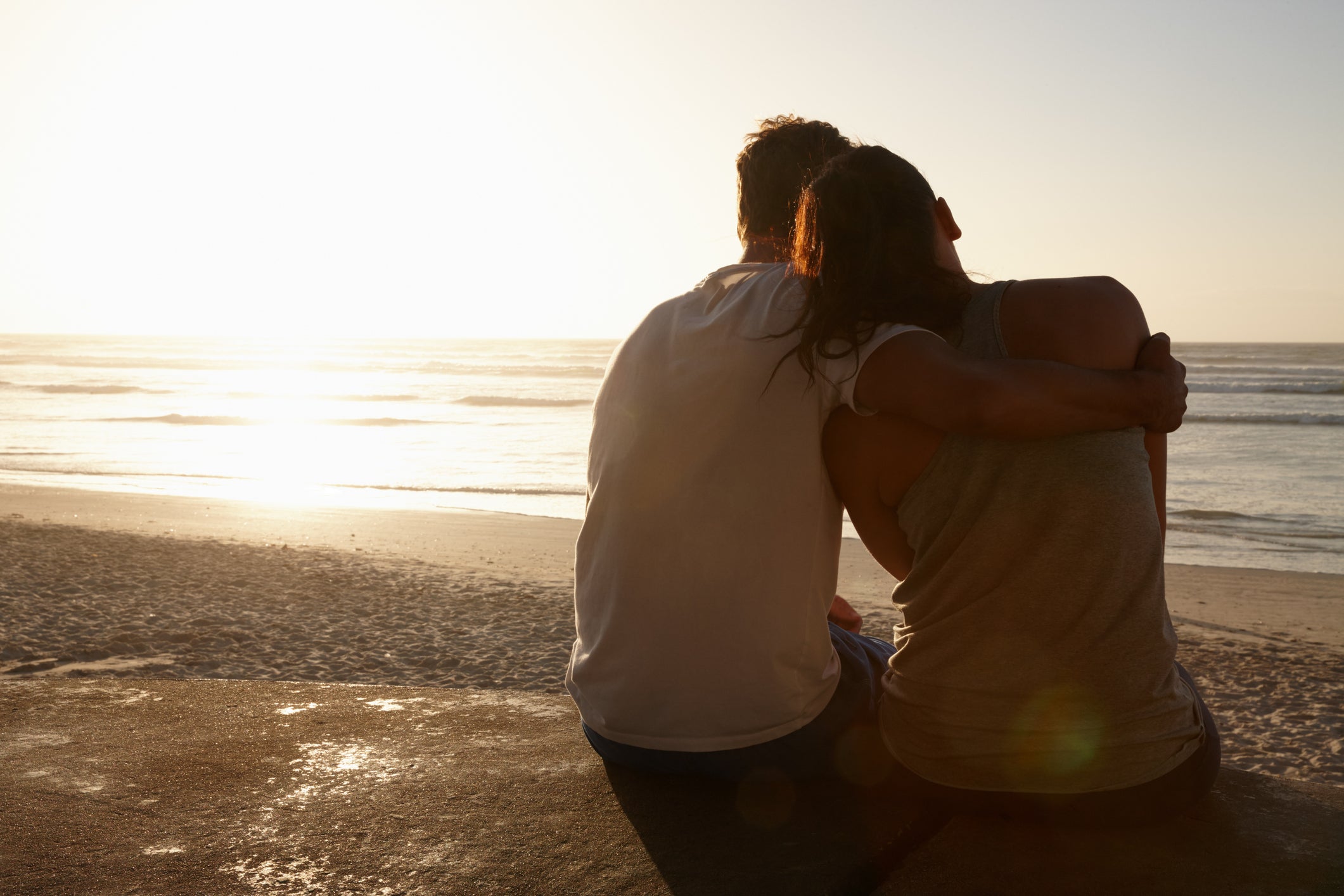 A man and woman hugging at the beach