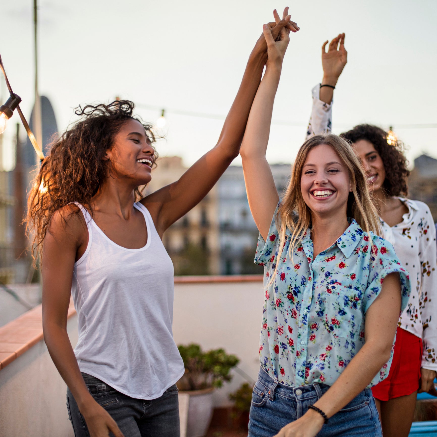 A group of happy woman with their hands in the air, celebrating an accomplishment