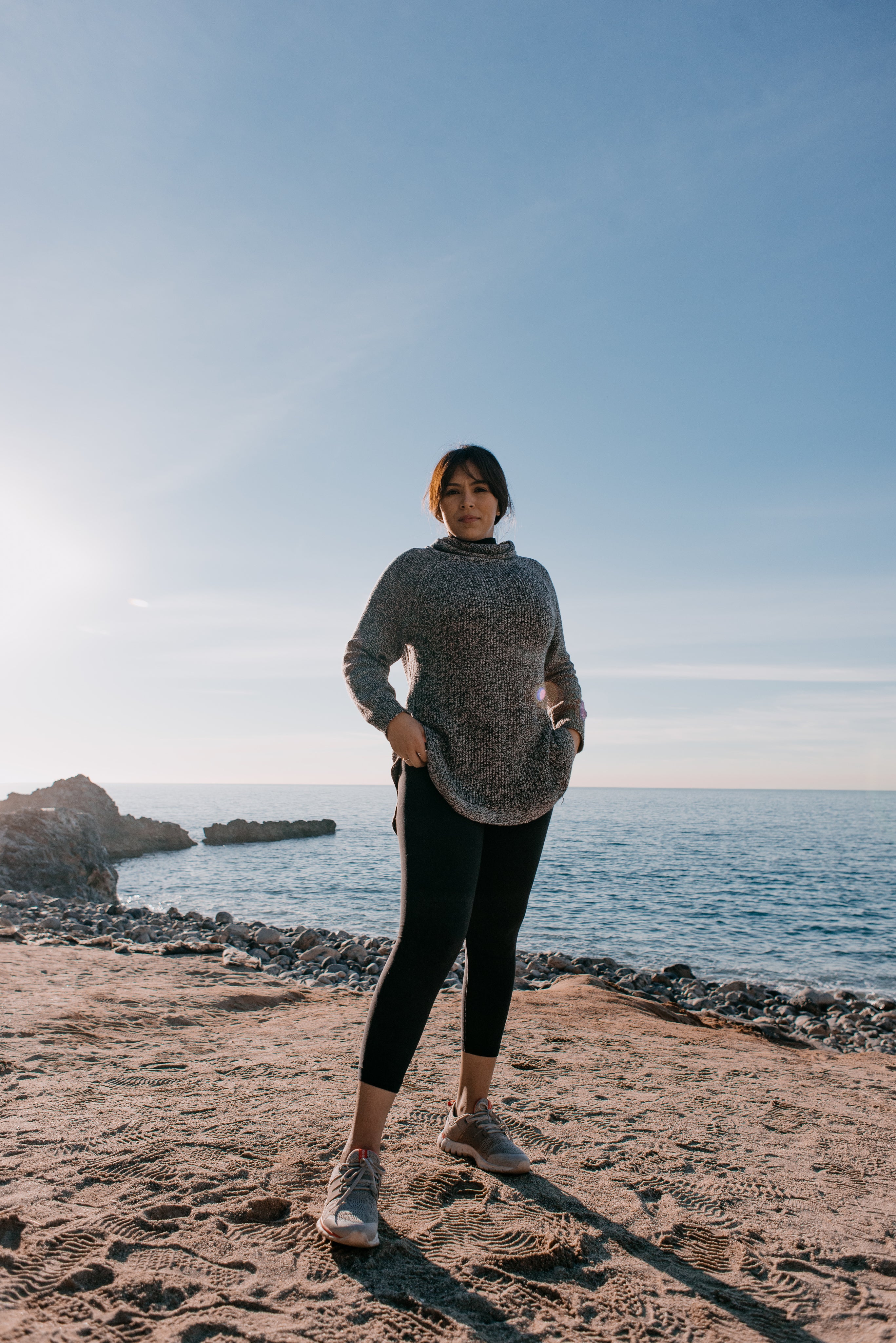 woman in sports clothes standing on beach