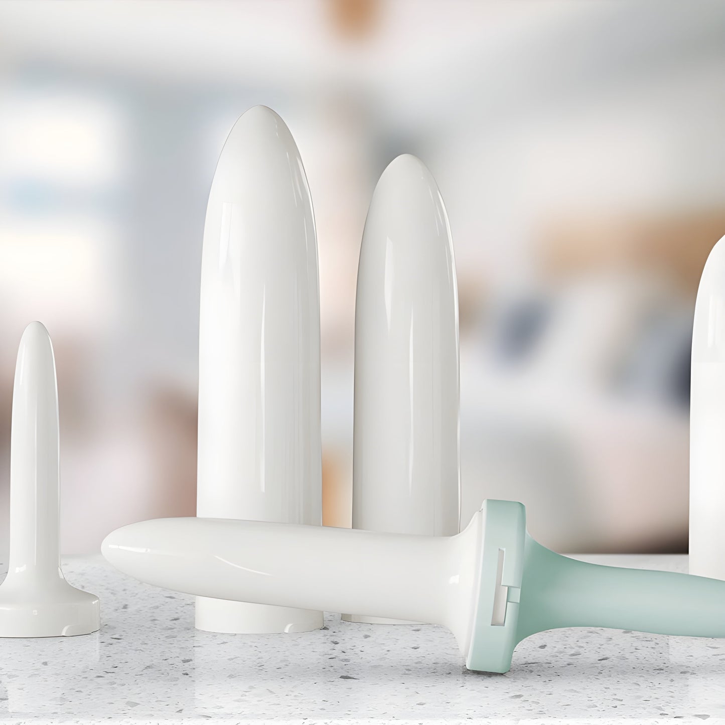 A set of dilators, including the handle and six sizes, sitting on a countertop. The dilators are used for things like vaginismus and other conditions.